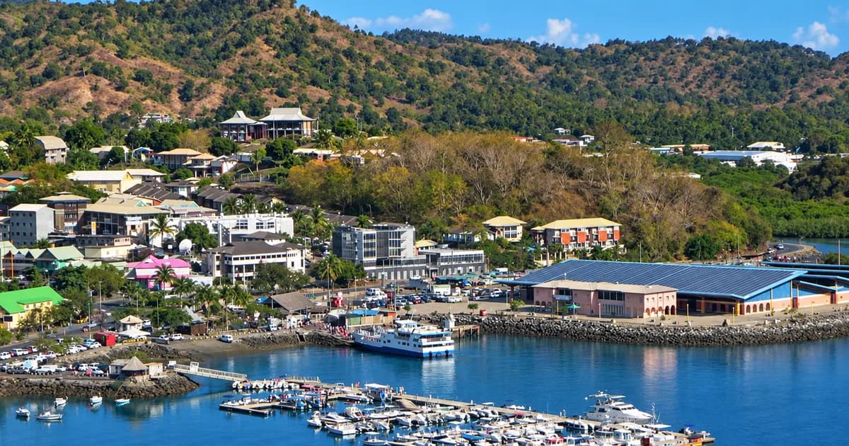 Vue aérienne du port de Mamoudzou à Mayotte avec bateaux, commerces et collines verdoyantes