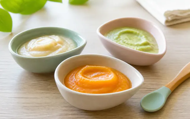 Bols de purées de fruits tropicaux et cuillère en silicone