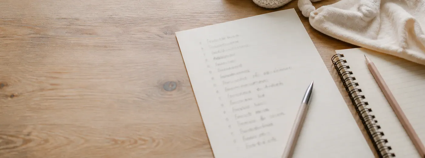 Liste de naissance manuscrite posée près d'un doudou