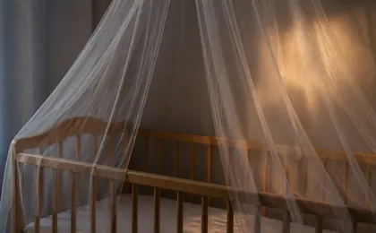 Moustiquaire drapée au-dessus d’un lit bébé, lumière du soir